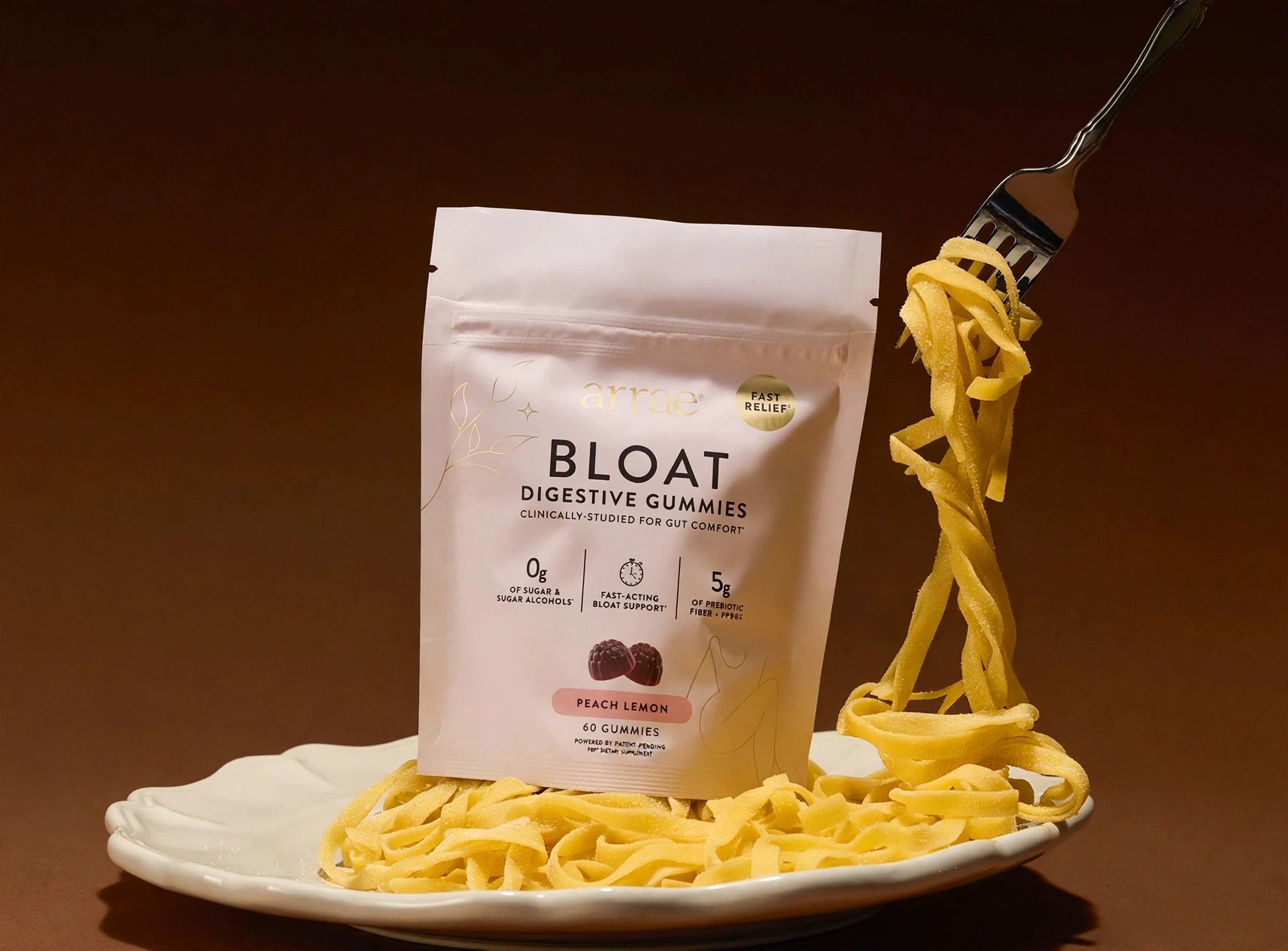 Arrae Bloat gummies pouch styled on a plate of pasta.