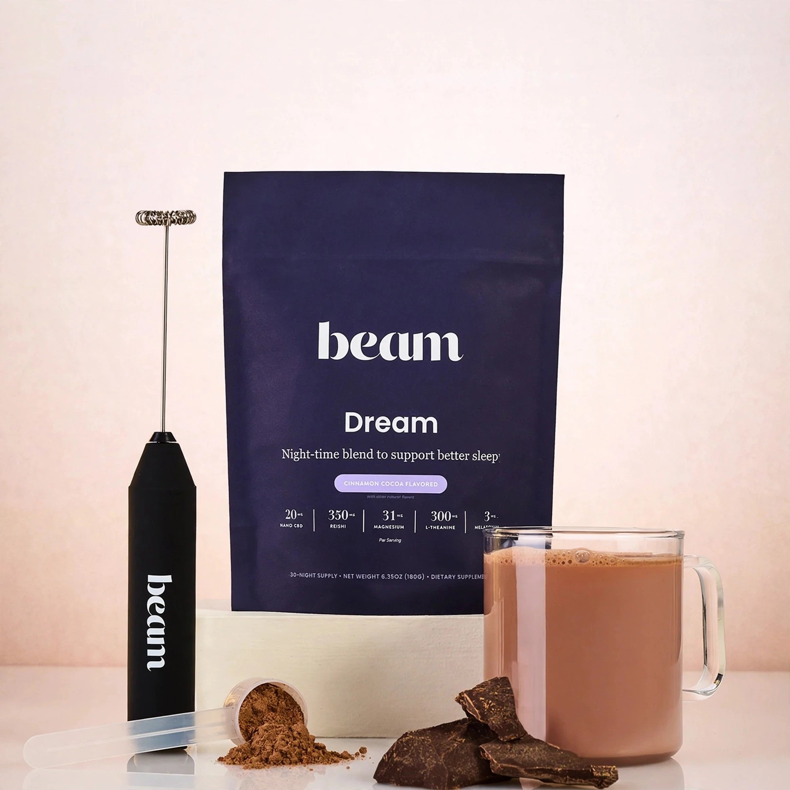 Beam Dream pouch beside a mug of chocolate with powder and frother.