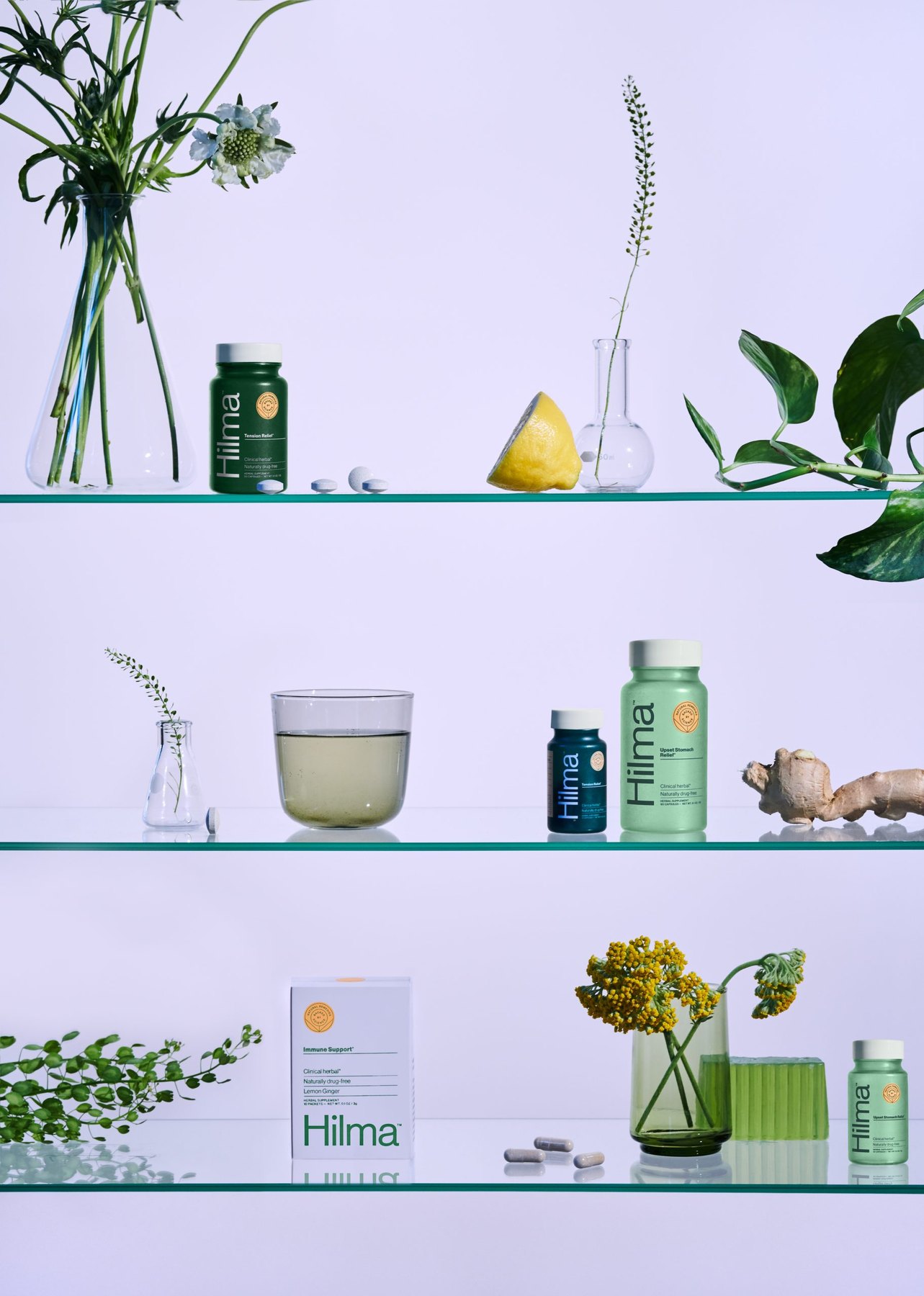 Glass shelves holding Hilma bottles with flowers ginger and lemon.