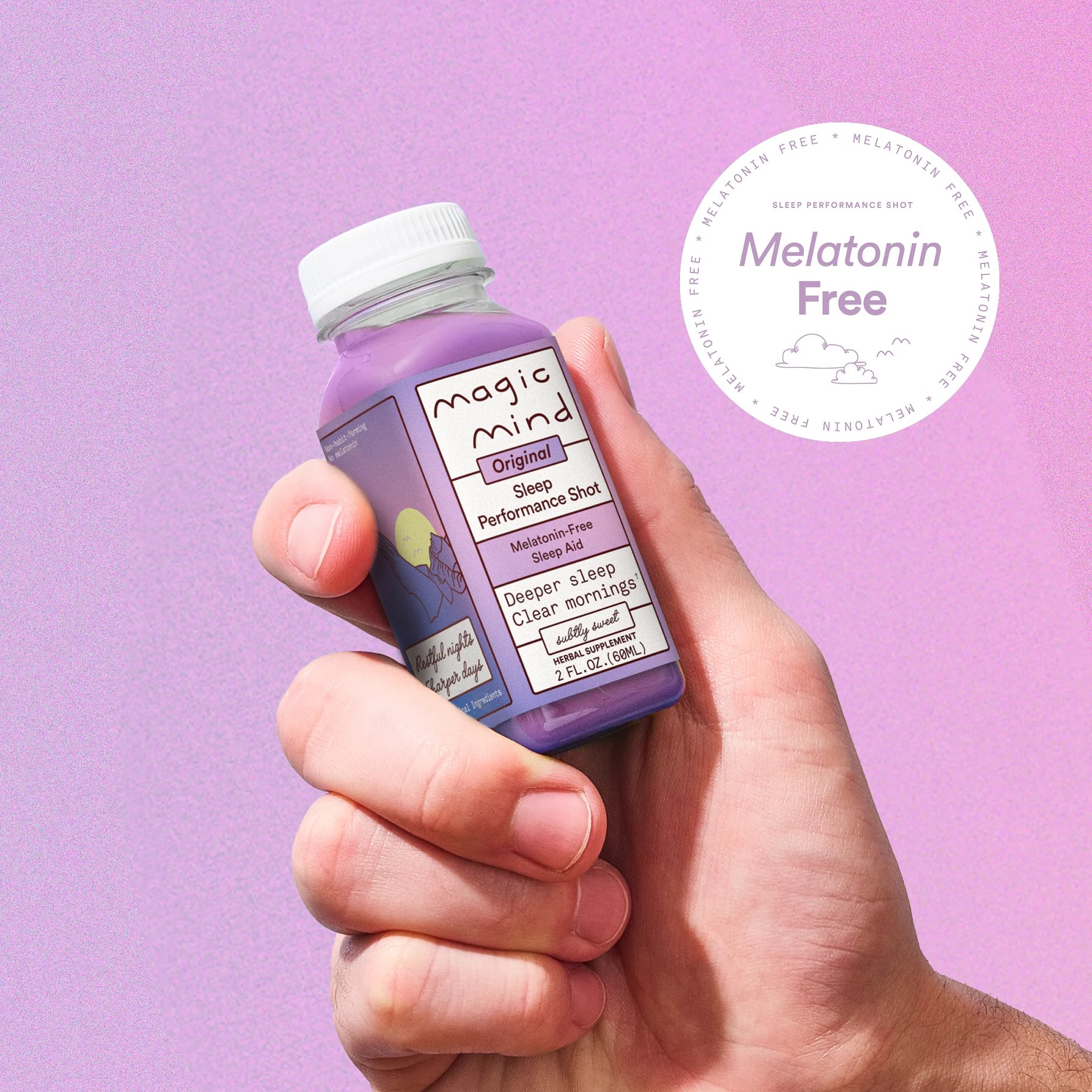 A hand holding a purple Magic Mind bottle against a purple backdrop.