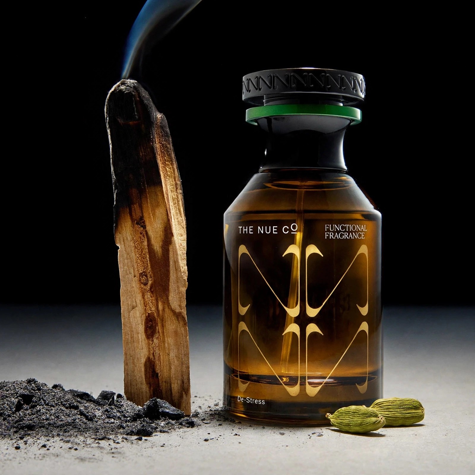 Fragrance bottle posed with smoking wood and spice.
