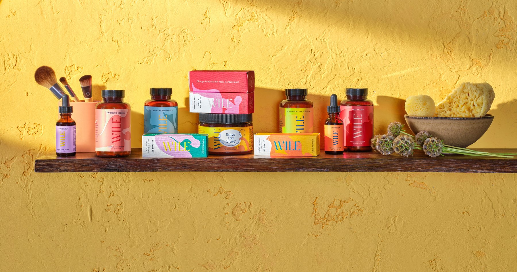 Assorted Wile bottles and jars arranged on wooden shelf.